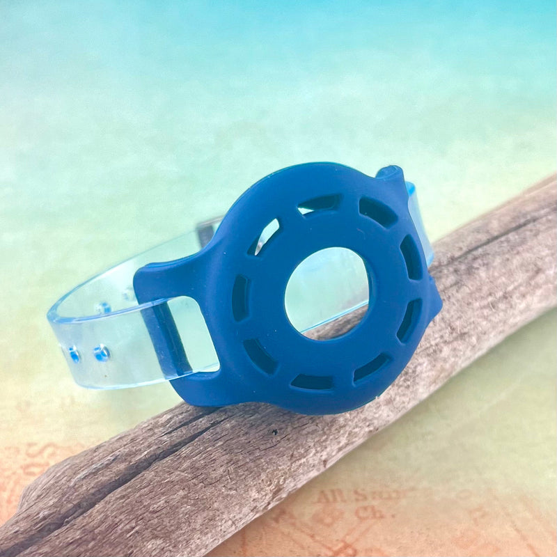 Blue Airtag bracelet displayed on a piece of wood.
