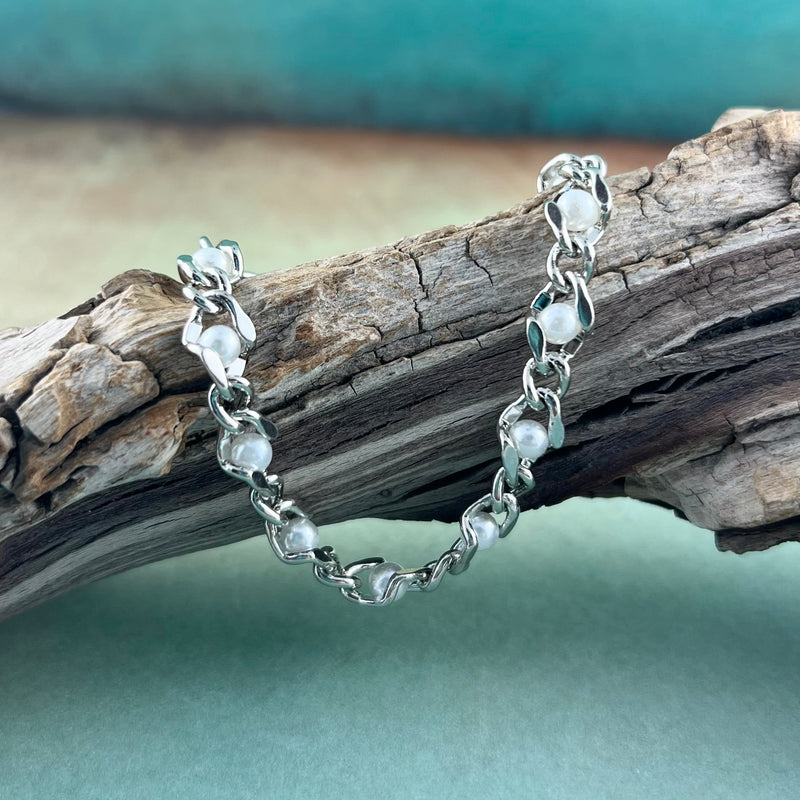 Silver and pearl chain replacement medical alert bracelet displayed on a piece of wood.