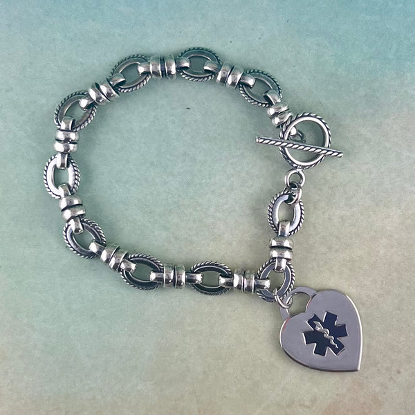 Silver medical alert charm bracelet with black star of life heart shaped medical charm.