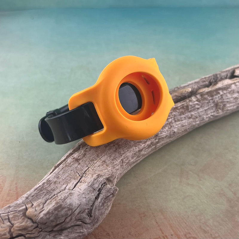 Black silicone Airtag bracelet with orange airtag holder displayed on a piece of wood.