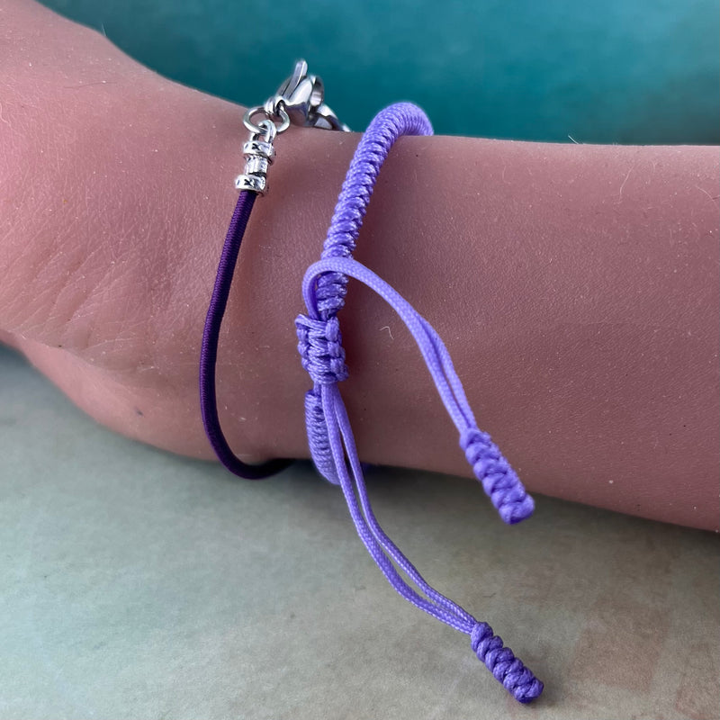 Purple cord stretch bracelet displayed on a wrist.